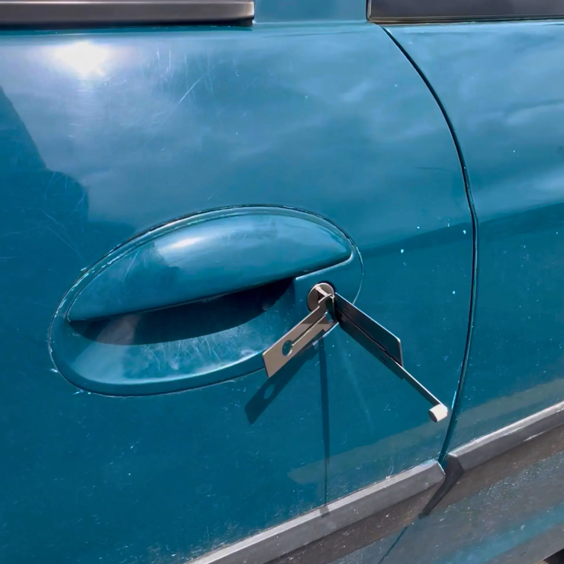 Ferramenta de chaveiro automotivo inserida na fechadura da porta de um veículo
